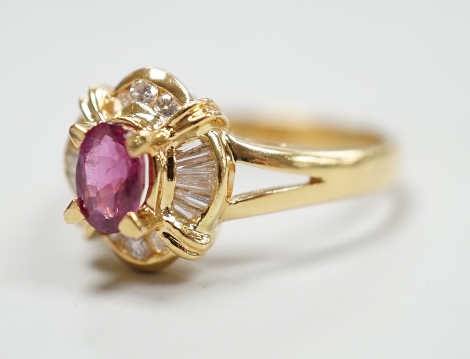 A modern 18ct gold, single stone ruby and trapeze and round cut diamond cluster set dress ring, size O, gross weight 4.7 grams.